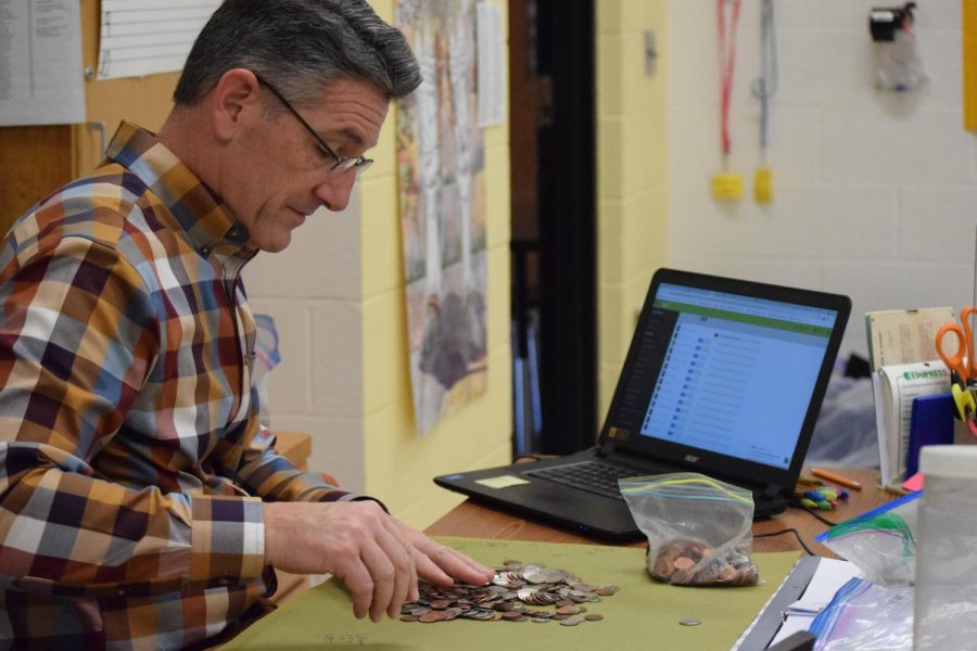 Mr. Larry Richmond counts the coins for the fundraiser. 
