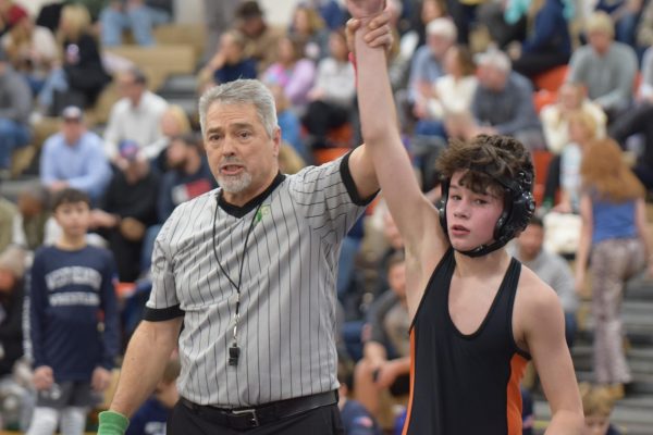 Hand up high: 7th grader Zane Stull winning a wrestling match after battling out his opponent at a home meet. Stull’s win was special because the student section was filled and Stull's dad, who wrestled in college, was watching too.